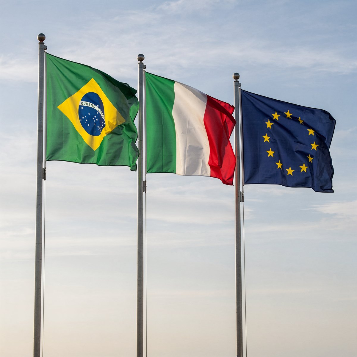 As bandeiras do Brasil, da Itália e da União Europeia lado a lado, hasteadas ao ar livre
